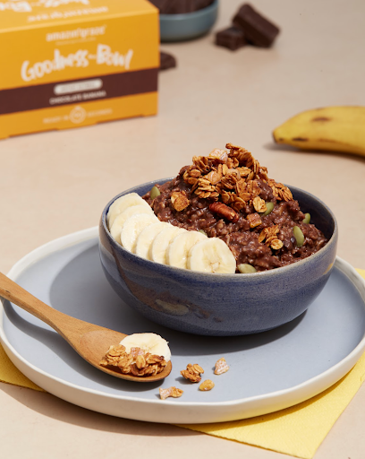 Amazin’ Graze Chocolate Banana Goodness Bowl topped with granola and banana slices beside its product box.