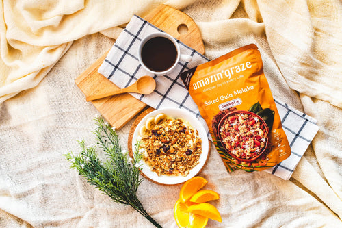 Bowl of granola and nut mix served with yogurt and fresh fruit, highlighting a balanced high-fiber breakfast option.